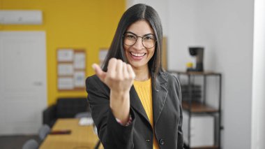 Genç, güzel İspanyol iş kadını güler yüzlü, kendine güvenen bir işadamı ofise gelip jest yapıyor.