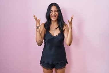 Siyah pijama giyen esmer kadın başarının çılgınlığını kutluyor. Kollarını kaldırmış, gözlerini kapatmış heyecanlı çığlıklar atıyor. Kazanan konsept 