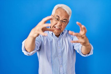 Gözlüklü İspanyol kıdemli adam öfkeden çıldırmış, elleri boğazlamaya çalışıyor, deli gibi bağırıyor. 