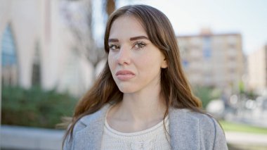 Ciddi bir ifadeyle genç İspanyol kadın parktaki kameraya bakıyor.