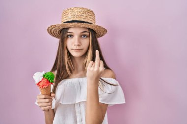 Teenager girl holding ice cream showing middle finger, impolite and rude fuck off expression 