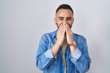 Soyutlanmış arka planda duran genç İspanyol adam gülüyor ve utanıyor kıkır kıkır kıkır kıkır kıkır gülüyor elleri, dedikoduları ve skandalları anlatıyor. 