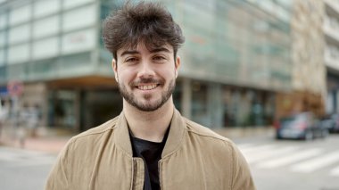 Sokakta kendinden emin gülümseyen İspanyol genç adam.