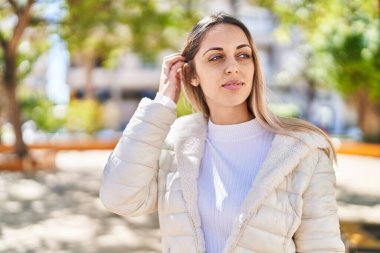 Young woman with relaxed expression standing at park