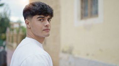 Sokakta ciddi bir ifadeyle duran İspanyol genç adam.