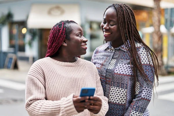 African American Women Friends Smiling Confident Using Smartphone Street — ストック写真