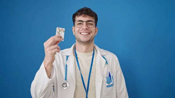 Giovane Ispanico Uomo Medico Possesso Pillole Isolato Sfondo Blu — Foto Stock