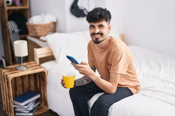 Joven Hispano Usando Smartphone Bebiendo Café Dormitorio — Foto de Stock