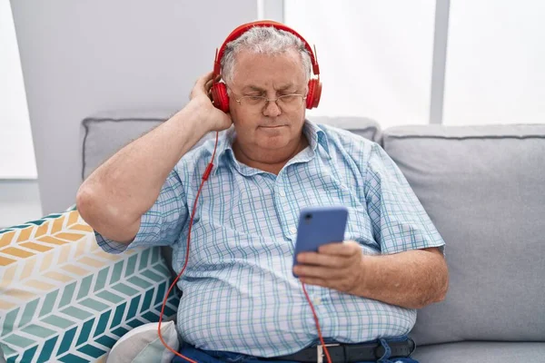 Middelbare Leeftijd Grijsharige Man Luisteren Naar Muziek Zitten Bank Thuis — Stockfoto