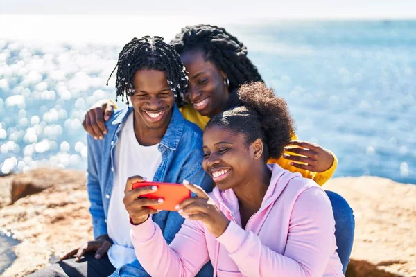 Afrika Kökenli Amerikalı Arkadaşlar Deniz Kenarındaki Kayalarda Oturan Akıllı Telefonları — Stok fotoğraf