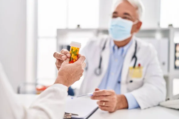 中年男子 医生和戴医疗面具的病人在诊所吃药 — 图库照片