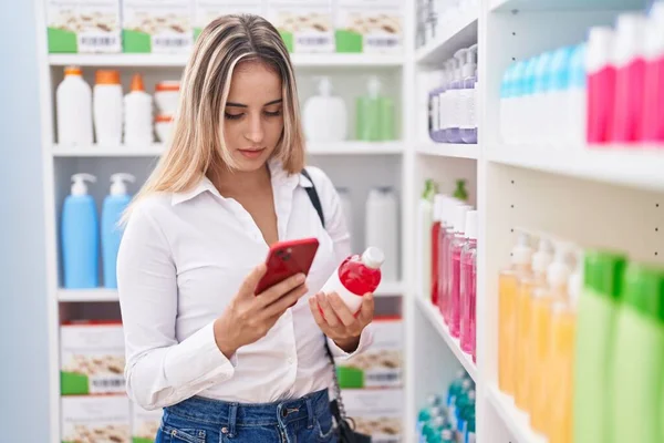 Young Blonde Woman Customer Using Smartphone Holding Medicine Bottle Pharmacy — Stockfoto