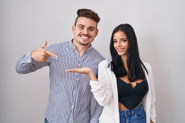 Young Hispanic Couple Standing White Background Amazed Smiling Camera While — Stock Photo, Image
