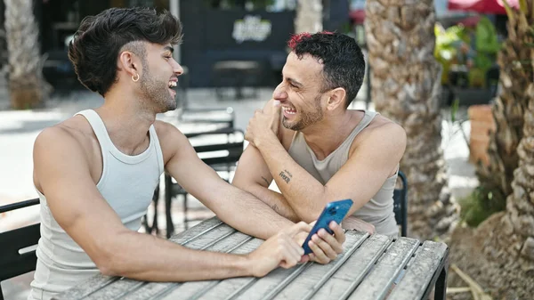 stock image Two men couple smiling confident using smartphone at coffee shop terrace