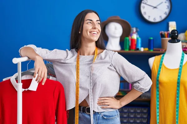Junge Schöne Hispanische Schneiderin Lächelt Selbstbewusst Kleiderständer Der Bekleidungsfabrik Gelehnt — Stockfoto