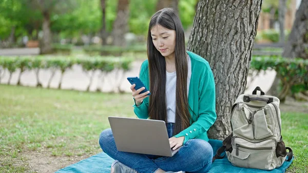 Genç Çinli Kadın Parkın Zemininde Dizüstü Bilgisayar Akıllı Telefon Kullanıyor — Stok fotoğraf