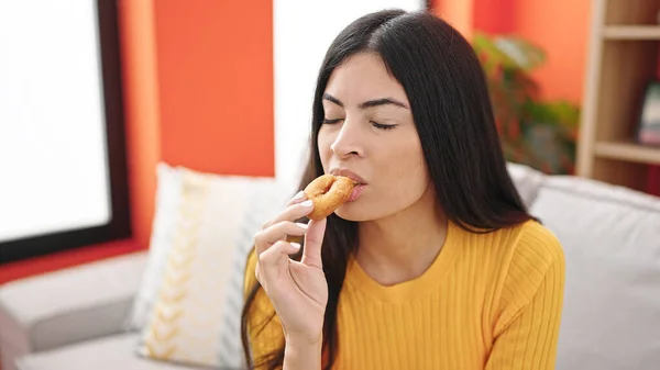 Ung Vacker Latinamerikansk Kvinna Äter Munk Sitter Soffan Hemma — Stockfoto
