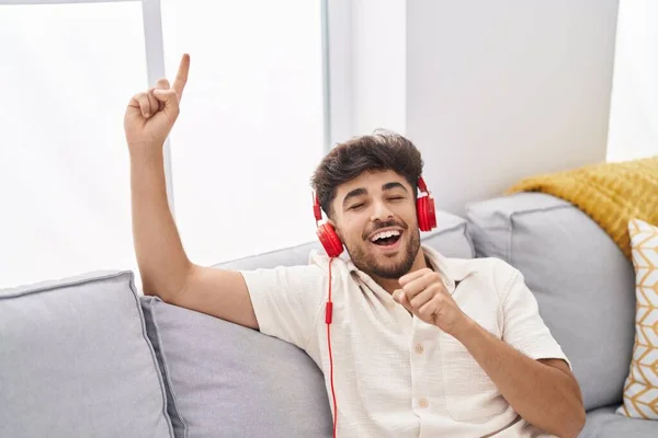 Ung Arabisk Man Sjunger Och Lyssnar Musik Sittandes Soffan Hemma — Stockfoto