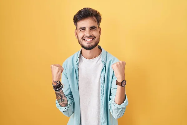 Ung Latinamerikansk Man Med Tatueringar Står Över Gul Bakgrund Mycket — Stockfoto