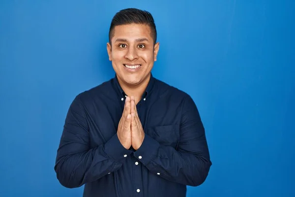 Hispanic Young Man Standing Blue Background Praying Hands Together Asking — Stock Photo, Image