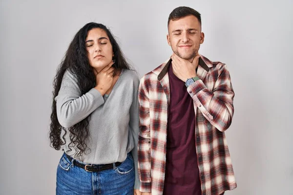 Unga Latinamerikanskt Par Står Över Vit Bakgrund Vidrör Smärtsam Hals — Stockfoto