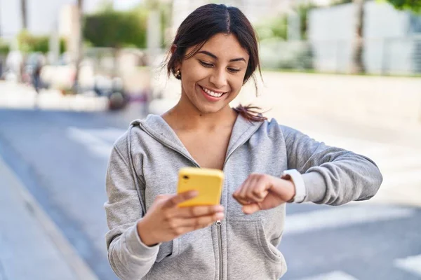 Young Hispanic Woman Wearing Sportswear Looking Stopwatch Using Smartphone Street — Stock fotografie
