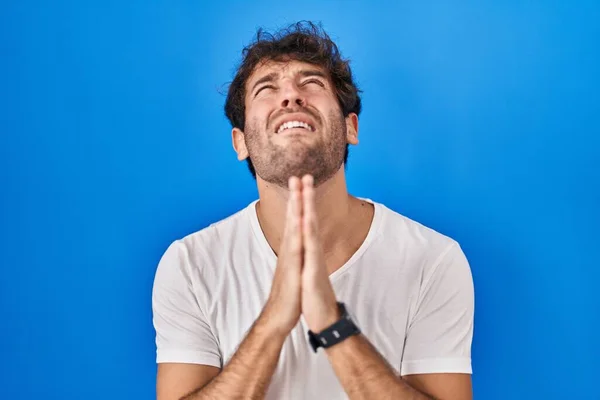 Hispanic Young Man Standing Blue Background Begging Praying Hands Together — Stok fotoğraf