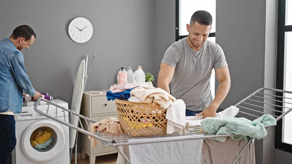 Two Men Couple Smiling Confident Hanging Clothes Laundry Room — Stock Photo, Image