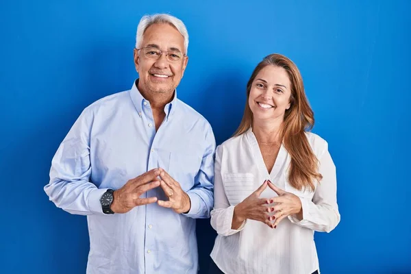 Medelålders Latinamerikanska Par Står Över Blå Bakgrund Händer Tillsammans Och — Stockfoto