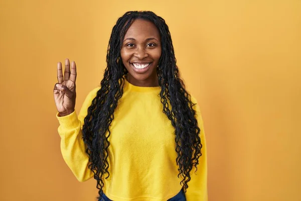 African Woman Standing Yellow Background Showing Pointing Fingers Number Three — Photo