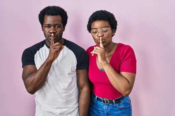 Young African American Couple Standing Pink Background Asking Quiet Finger — Stock Photo, Image