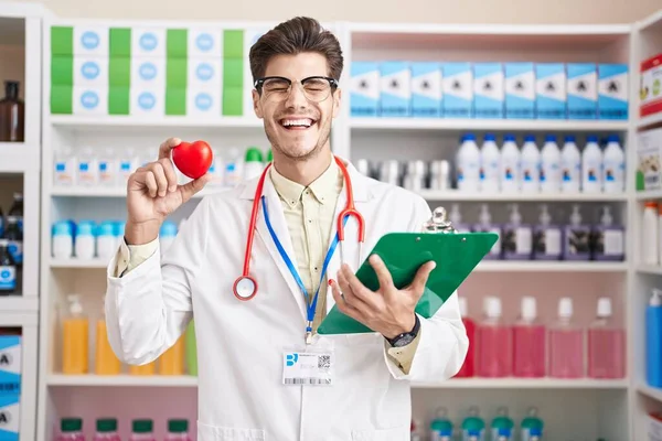 Jovem Hispânico Trabalhando Farmácia Farmácia Farmácia Segurando Coração Sorrindo Rindo — Fotografia de Stock