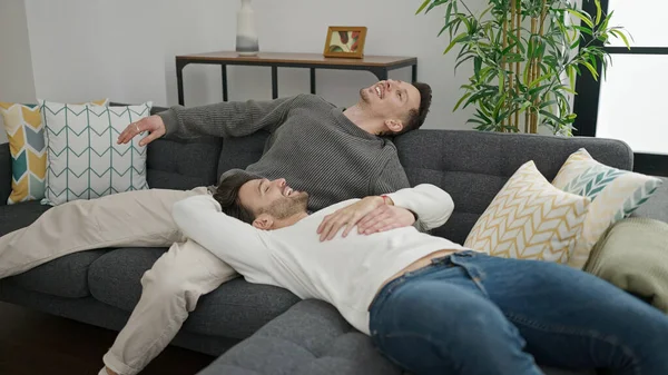 Δύο Άνδρες Ζευγάρι Αγκαλιάζονται Καθισμένοι Στον Καναπέ Στο Σπίτι — Φωτογραφία Αρχείου