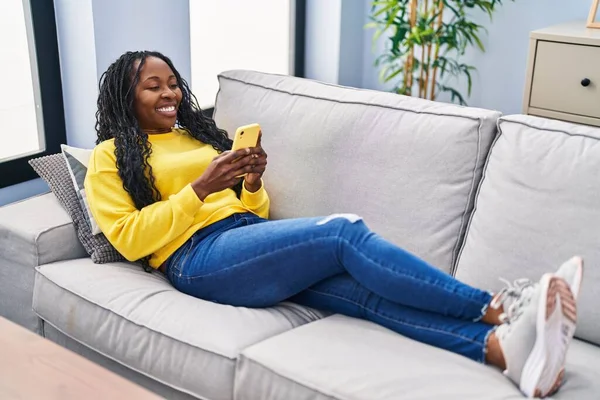 African American Woman Using Smartphone Lying Sofa Home — Foto de Stock