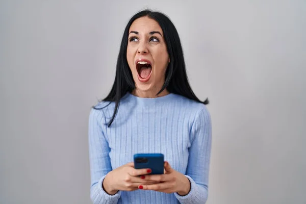 Ισπανίδα Γυναίκα Που Χρησιμοποιεί Smartphone Θυμωμένη Και Τρελή Ουρλιάζοντας Απογοητευμένη — Φωτογραφία Αρχείου