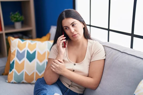 Young Beautiful Hispanic Woman Talking Smartphone Serious Expression Home — Stock Photo, Image