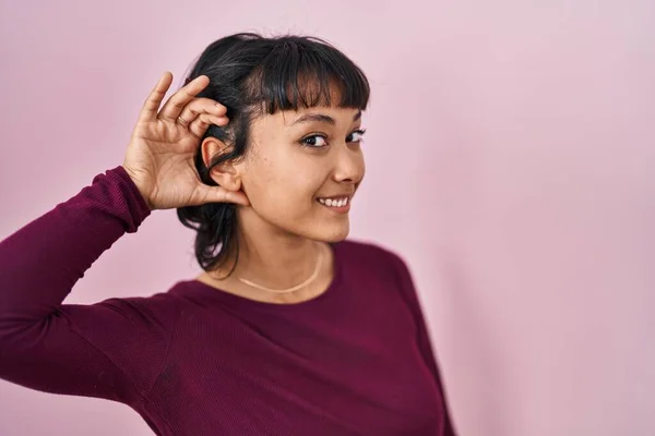 Young Beautiful Woman Standing Pink Background Smiling Hand Ear Listening — Fotografia de Stock