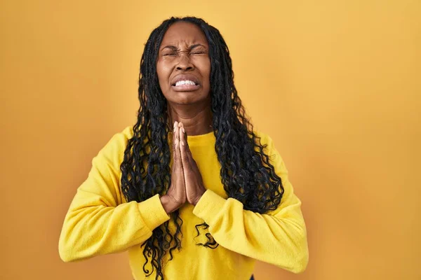Africká Žena Stojí Nad Žlutým Pozadím Prosí Modlí Rukama Sobě — Stock fotografie
