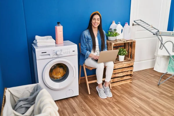 Young Beautiful Hispanic Woman Using Laptop Waiting Washing Machine Laundry — Foto de Stock