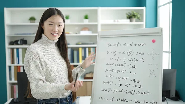 若い中国人女子学生笑顔自信を持って説明する数学演習で図書館大学 — ストック写真