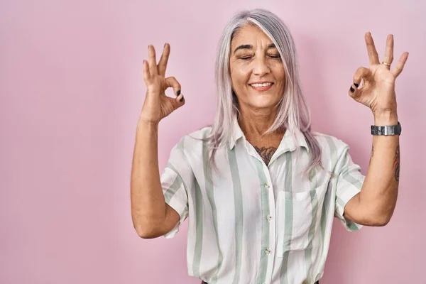 Kobieta Średnim Wieku Siwymi Włosami Stojąca Różowym Tle Relaksuje Się — Zdjęcie stockowe