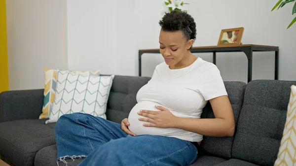 Young Pregnant Woman Touching Belly Sitting Sofa Home — Stock fotografie