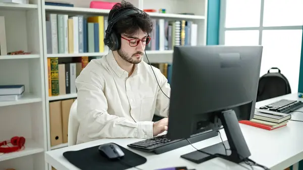 Young Hispanic Man Student Using Computer Headphones Studying Library University — Fotografia de Stock