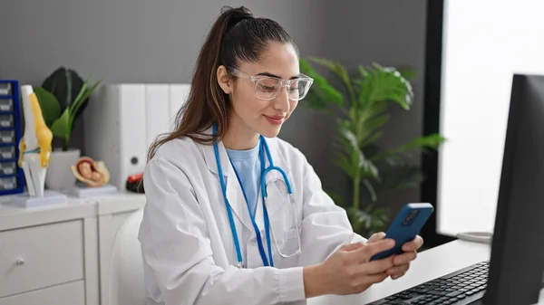 Νεαρή Όμορφη Ισπανόφωνη Γιατρός Χρησιμοποιώντας Smartphone Που Εργάζονται Στην Κλινική — Φωτογραφία Αρχείου