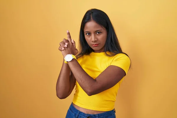 Sarı Arka Planda Duran Genç Hintli Kadın Sembolik Bir Silahla — Stok fotoğraf