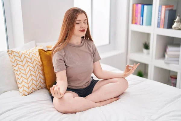 Young Redhead Woman Doing Yoga Exercise Sitting Bed Bedroom — Zdjęcie stockowe