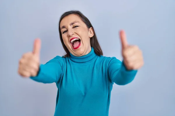 手で積極的なジェスチャーを行うことを承認孤立した背景の上に立っている中年のパニック女性 親指アップ笑顔と成功のために幸せ 勝者のジェスチャー — ストック写真