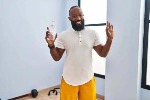 Africký Američan Nosí Sportovní Oblečení Drží Hydroalkoholový Gel Dělá Znamení — Stock fotografie