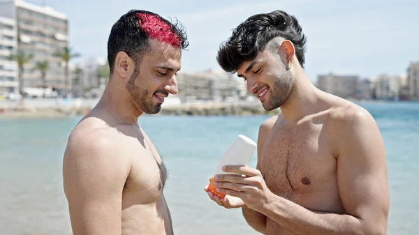 两名男子夫妇在海滩涂防晒霜 — 图库照片