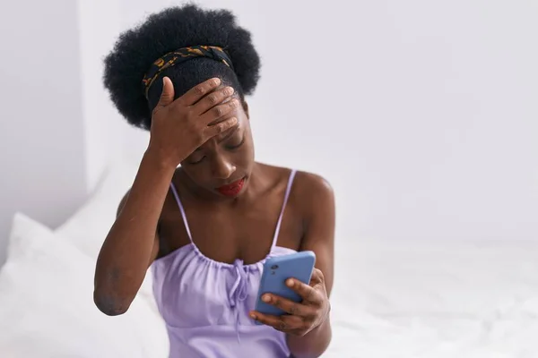 African American Woman Using Smartphone Serious Expression Bedroom —  Fotos de Stock
